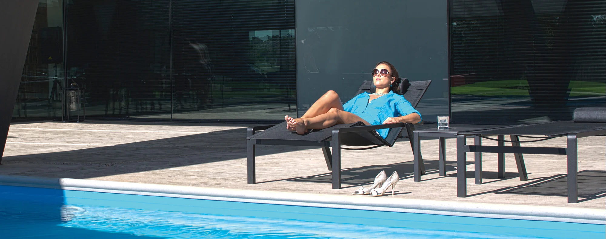 Woman lying on Alura aluminium sun lounger in black